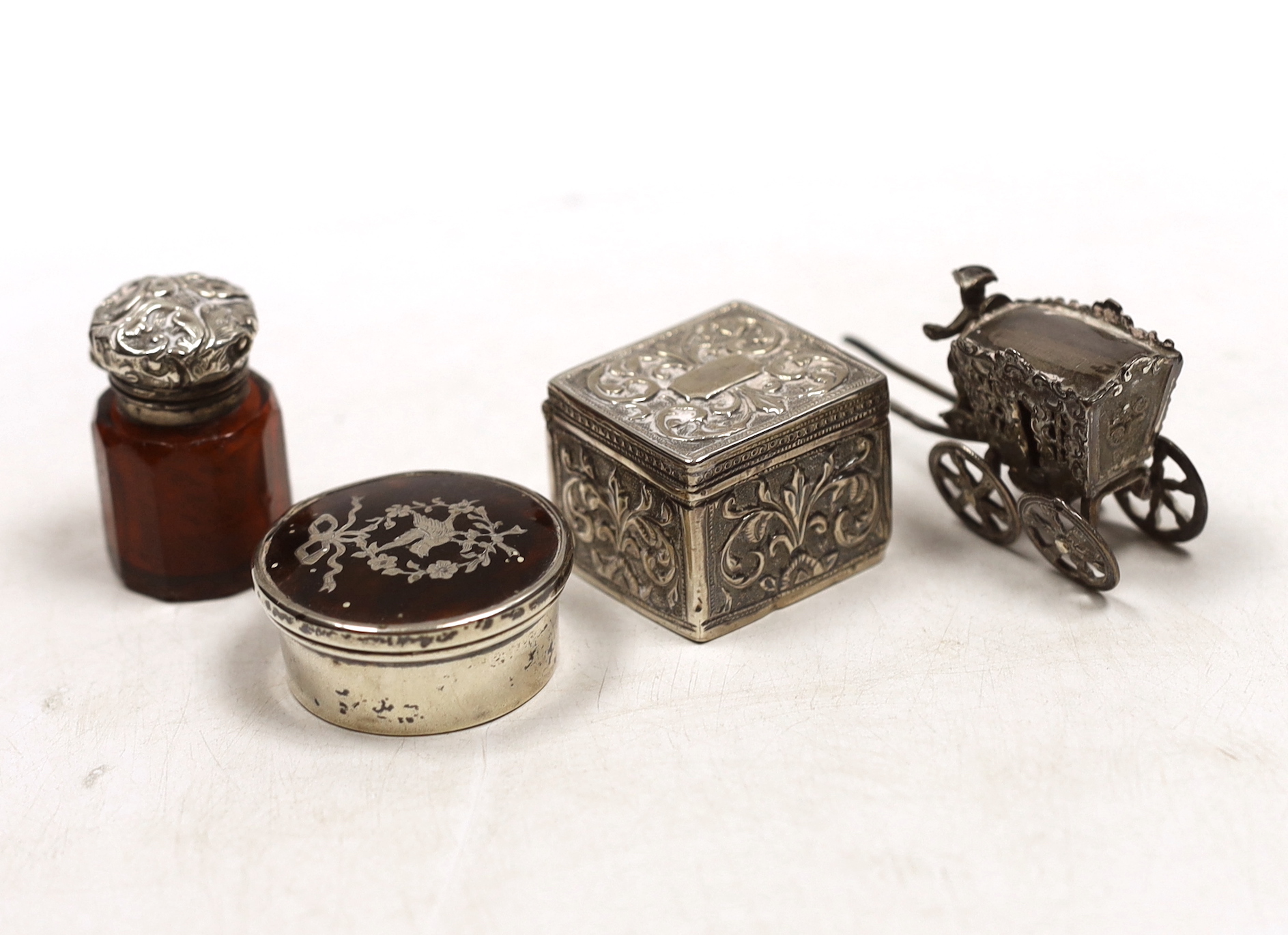A small George V silver and tortoiseshell piquet pill box, 41mm and three other items including a white metal model of a carriage, pill box and scent bottle.